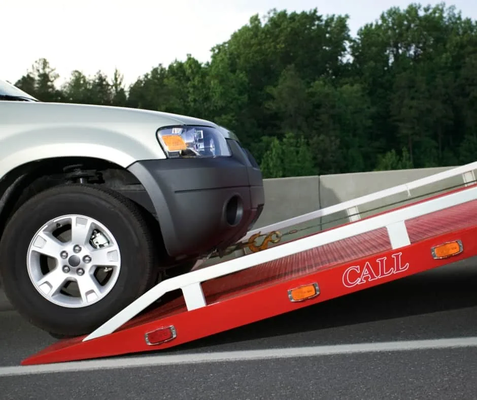 Hamilton tow truck loading a vehicle on a residential street