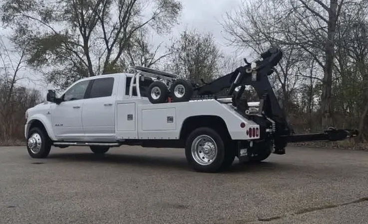 Hamilton wrecker equipment securing damaged vehicle